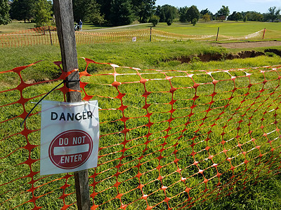 在高尔夫球场上 危险不得进入标志和橙色栅栏图片