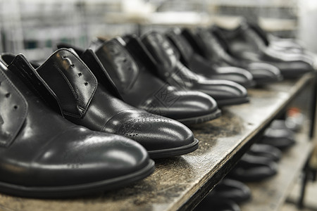 架子上有很多新的黑闪亮的鞋子 鞋厂 成品仓库皮革工人脚趾检查机器靴子男人作坊时尚制造业图片