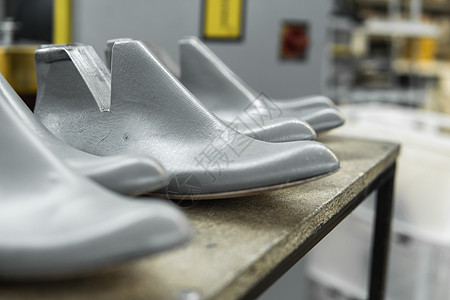塑料鞋楦用于制鞋 用于制造现代鞋的塑料鞋楦行 木架子上有很多塑料鞋楦 用于鞋子设计的设备产品工具材料制造业工艺脚趾网格剪裁解剖学背景图片