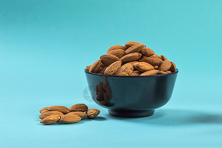 蓝色背景的杏仁特写维生素食物核桃小吃季节活力盐渍营养饮食水果图片