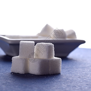 蓝底白盘中糖和糖的甘糖立方体烹饪甘蔗陶器盘子颗粒状重量水晶粮食精制蔗糖图片