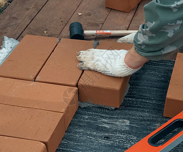 一个人建砖墙 布瑞克把解决方案放上去了 砖房的建造工具石工安装安全帽住房工作劳动建设者工作服石匠图片