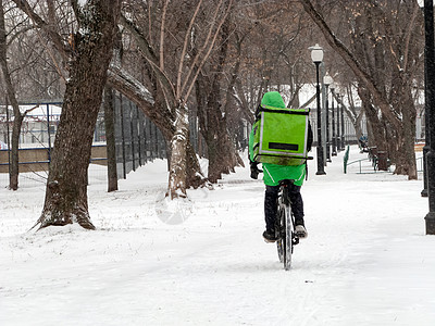 24小时从咖啡馆和餐馆送货服务 带外卖 乘自行车携带绿色异热背包的快递员男人派遣街道运输工人盒子顾客食物技术男性图片