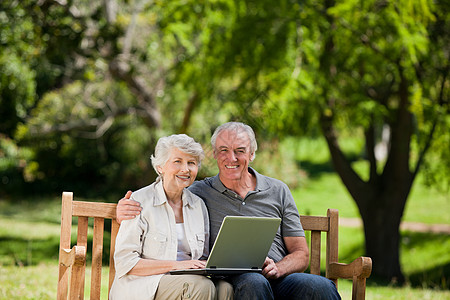 老年夫妇看笔记本电脑座位夫妻笑声男人农村相机拥抱女性男性公园图片
