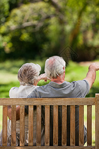 坐在长椅上 背对着镜头的一对夫妇农村拥抱座位男人退休微笑女性夫妻相机笑声图片