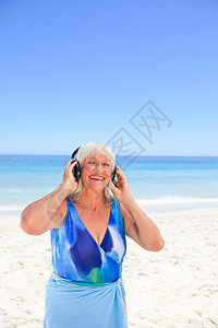 听海边音乐的年长女人内衣腹部海洋女孩皮肤游泳衣微笑退休腰部泳装图片
