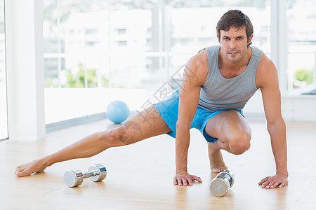 运动男子在健身工作室做伸展锻炼竞技地面健身室身体护理灵活性短裤拉伸训练闲暇图片