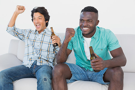 足球球迷在看电视时欢呼双手扇子观众电视胜利运动游戏男性支持者男人背景图片