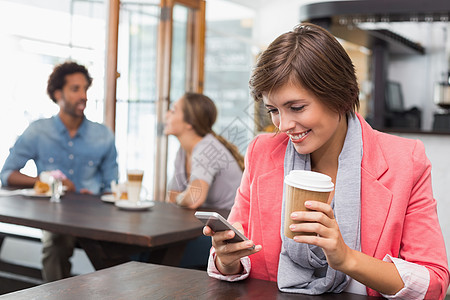 漂亮的黑发美女送短信来喝咖啡闲暇行业快乐咖啡屋男人桌子活动饮料咖啡杯女士背景图片