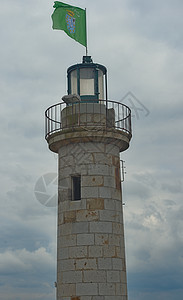 在法国坎昆举行的有绿色布丁旗的石灯塔旅游旅行天空建筑学花岗岩港口警告天气蓝色地标图片