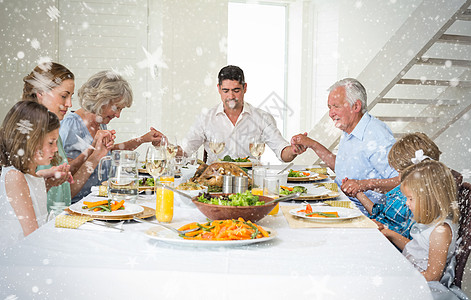 家庭在餐桌吃饭前一起祈祷的复合形象 在饭桌上共聚一堂图片