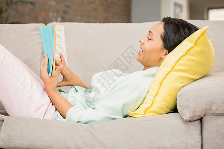 黑头发笑脸 看书休息室女性文学长发微笑公寓棕色住所客厅沙发快乐的高清图片素材
