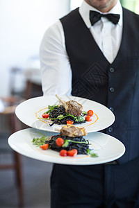 服务员显示菜盘男人服务酒店男性晚餐衬衫盘子食物餐厅马甲背景图片