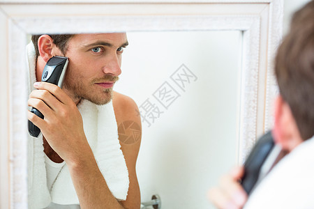 年轻男子用短发刮胡子房子皮肤反射男性卫生剃须刀家庭生活剃须公寓修剪图片