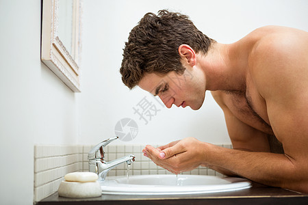 洗脸的人在浴室洗脸公寓用品住所膀子飞溅家居镜子脸盆男人双手图片