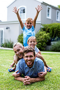 带着双臂在院子里与家人一起举起的男孩图片