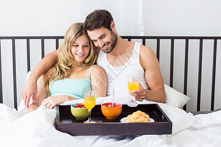 年轻夫妇吃早餐的肖像感情乐趣女士勺子夫妻面包托盘男性公寓玻璃图片