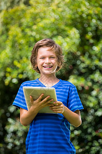 一个小男孩笑着用平板电脑背景图片