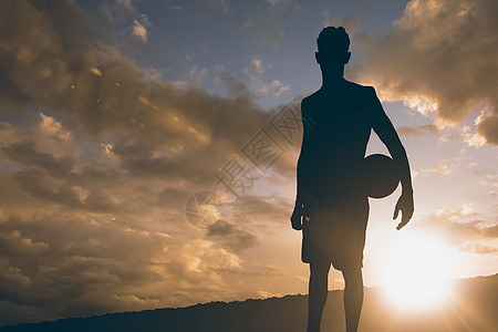 冲浪板球体育运动员举行篮球比赛的复合形象男性日落阳光运动微笑运动服男人天空太阳背景