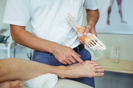 向病人解释脚模模型的物理治疗师背景图片