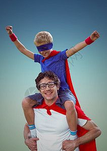 穿着红色披风和面具的快乐父亲和儿子玩得开心图片