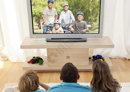 家庭在起居室看电视自行车宽屏乐趣丈夫享受休闲锻炼兄弟姐妹妻子公园图片