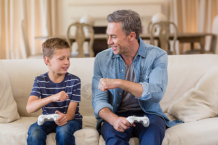 父亲和儿子在客厅玩电子游戏时 互相拳打拳击相撞图片