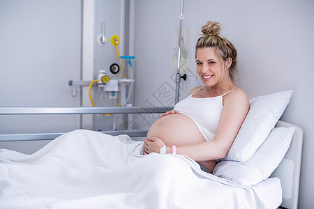 孕妇在医院床上休息时的肖像葡萄糖背心孕妇装专注器材点滴腹部快乐毯子保健背景图片