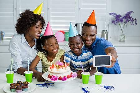 家人在家庆祝生日节日派对快乐童年手机女儿母亲男人稻草父亲自拍儿子回忆图片