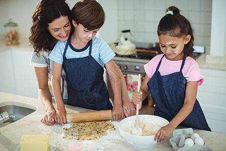 母亲和孩子在厨房做饼干公寓混血家庭生活黄油滚动准备台面压片亲密感女儿图片