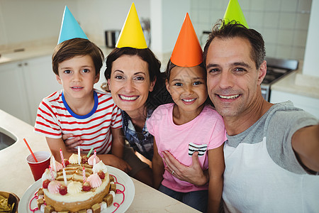 在庆祝生日时 快乐的一家人拿自拍回忆房子公寓技术女儿母亲父亲沟通派对孩子图片