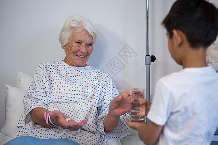 男孩给重病患者一杯水喝医学病人疾病医疗情况男性职场药物药品服务图片