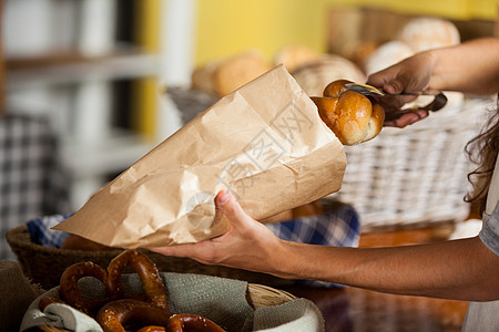 面包店工作人员用纸袋包装面包挑战推销员闲暇营业员烘焙柜台耐力服务包子店铺图片