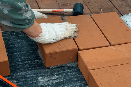 一个人建砖墙 布瑞克把解决方案放上工作服工人建设者石匠工具男人石工劳动控制板房子图片