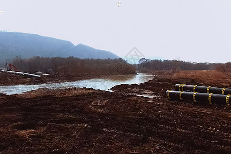 臀大肌跨越河流修建一条输油管 困难在地上活力管子建筑运输起重机生产压力补给品毛虫操作背景