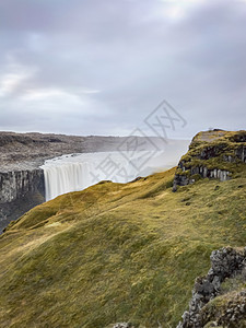 冰岛的Dettifos瀑布长时期水暴露于厚厚苔和草层后面边缘的水面图片