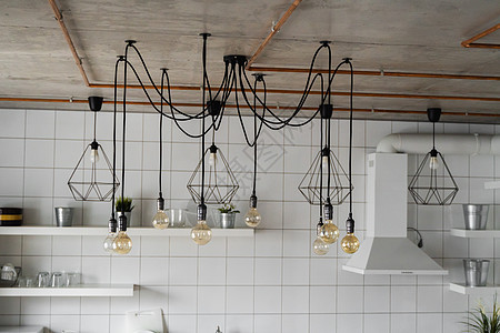 在舒适公寓的现代厨房上点着 旧式豪华室内照明灯作为家居装饰品吊灯家具力量枝形风格餐厅活力天花板艺术玻璃图片