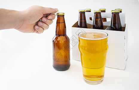 一个人开一个皮尔斯纳风格的瓶子 拉格棕色奶瓶西装包 盛满一品脱啤酒腹肌啤酒瓶酒精绿色饮料玻璃茶点白色酒吧液体图片