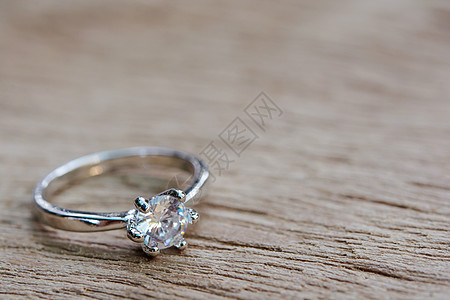 钻石戒指 有复制空间的木板木上的结婚戒指圆圈订婚宏观木头钻戒庆典桌子新娘结婚戒指调子背景