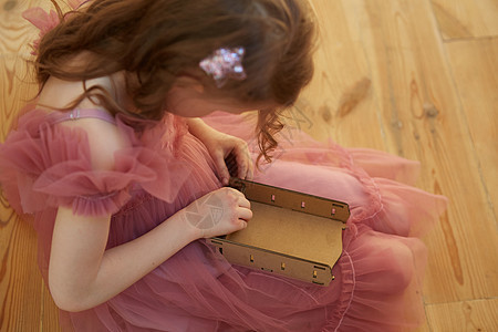 一个女孩在玩纸板玩具娃娃屋家具裙子木头婴儿生态金发幼儿园家庭孩子们房间游戏图片