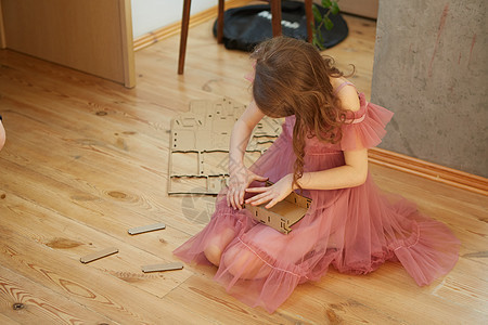 一个女孩在玩纸板玩具娃娃屋家具乐趣金发窗户快乐卧室苗圃幸福童年裙子房子图片