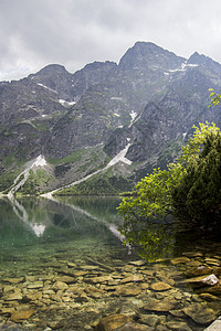 美丽的夏日高山湖景覆盖着绿树和天空中的阳光 山在水中的倒影 水晶般清澈的水 欧洲 阿尔卑斯山太阳旅行风景山脉国家荒野反射叶子森林图片