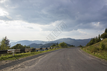 乌克兰喀尔巴阡山脉弯曲的蛇形山林公路 蓝天下的沥青公路和山脉 山林中空荡荡的柏油路高速公路 背景是多云的天空图片