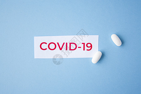 蓝色背景的covid19引文发烧医院诊所胶囊生物保健药品症状药片抗生素图片