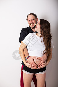 美丽的孕妇和她英俊的丈夫抱着肚子的切成一幅美容的形象家庭妈妈夫妻男人婴儿怀孕孩子男性母亲女孩图片