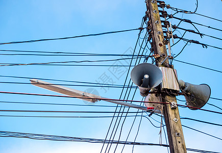 云下和蓝天空下的电线杆和电缆站立力量基础设施喇叭技术蓝色广播太阳扩音器金属图片