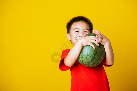 快乐的肖像亚洲儿童或可爱的小男孩穿着红色 T 恤玩耍时迷人的微笑拿着没有被切开的完整西瓜蔬菜童年孩子营养假期饮食男生乐趣小吃男人图片