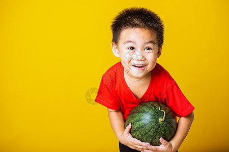 亚洲儿童或小孩可爱的小男孩穿着红色 T 恤玩耍时迷人的笑容拿着满满的西瓜工作室童年孩子小吃男生假期婴儿水果男人食物图片