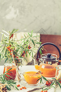 杯子和茶壶热辣茶 与海角 果酱叶子鼠李治疗橙子浆果饮料桌子植物水果食物图片
