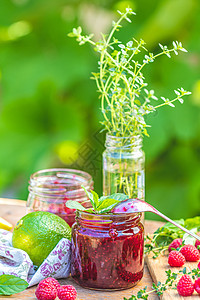 生锈木制桌边的草莓果酱和新鲜树莓早餐勺子浆果玻璃叶子季节晴天美食食物甜点图片